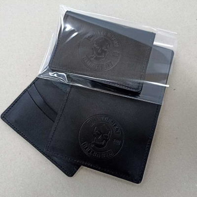 Черен кожен кардхолдер/портфейл с релефно лого на череп. Частично опакован в прозрачно пликче.