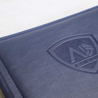 Близък план на тъмносиня кожена корица с щампован щит, съдържащ буква Л, волейболна топка и надпис Левски София.