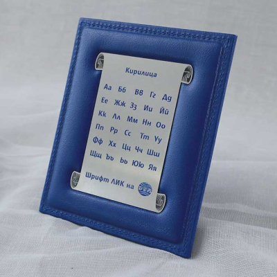 Малка синя кожена рамка с метална плочка, гравирана с буквите от кирилицата и надпис Шрифт ЛИК.